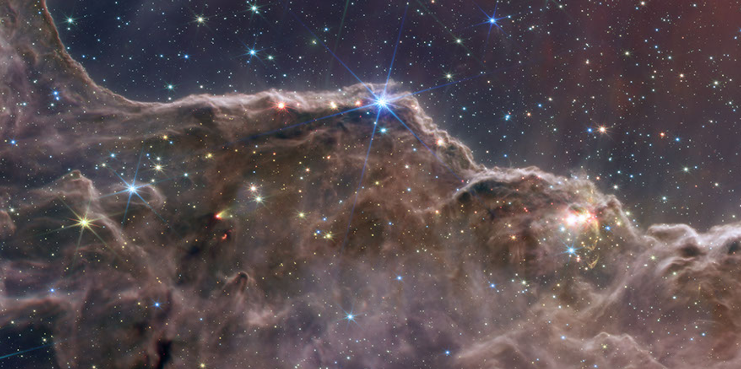 Webb Space Telescope image of the "Cosmic Cliffs" in the Carina Nebula, showing towering columns of gas and dust where new stars are forming.