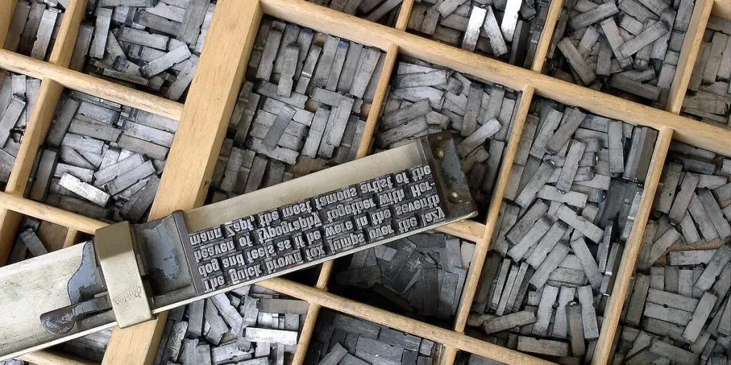Letter types in a type case. The plate says "The quick brown fox jumps over the lazy dog and feels as if he were in the seventh heaven of typography together with Hermann Zapf.